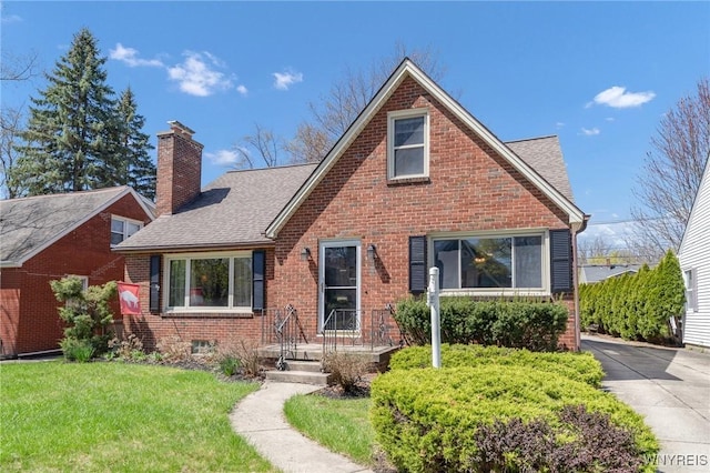 view of front facade with brick siding, a chimney, roof with shingles, and a front lawn
