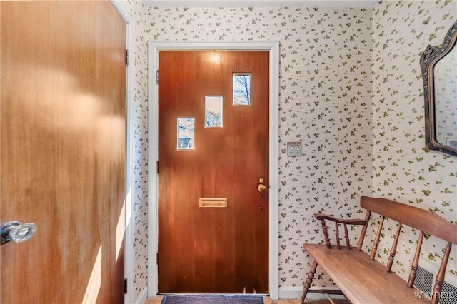 doorway featuring baseboards and wallpapered walls
