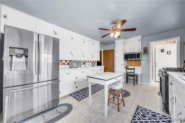 kitchen featuring white cabinets, ceiling fan, appliances with stainless steel finishes, light countertops, and light floors
