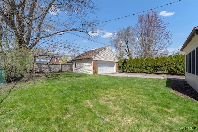 view of yard featuring fence, an outbuilding, and a detached garage