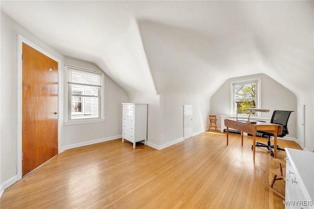 office with baseboards, light wood-style flooring, and vaulted ceiling