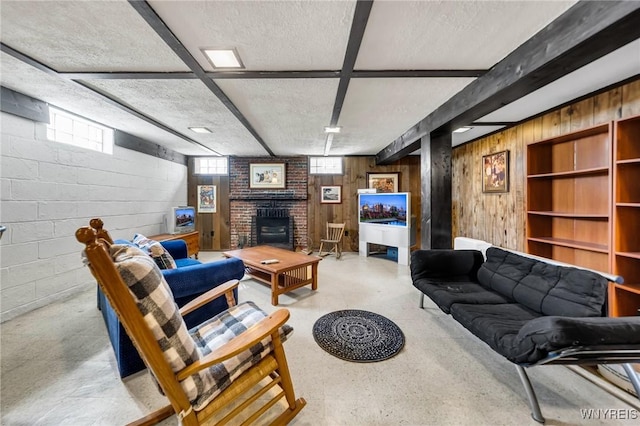 living area with concrete block wall, concrete floors, wooden walls, and a fireplace