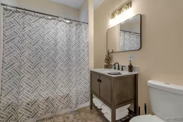 full bathroom with toilet, tile patterned floors, curtained shower, and vanity