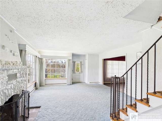 unfurnished living room with carpet flooring, a textured ceiling, stairs, and a fireplace