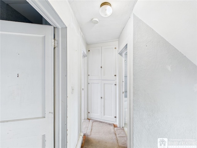 hall with a textured wall and carpet