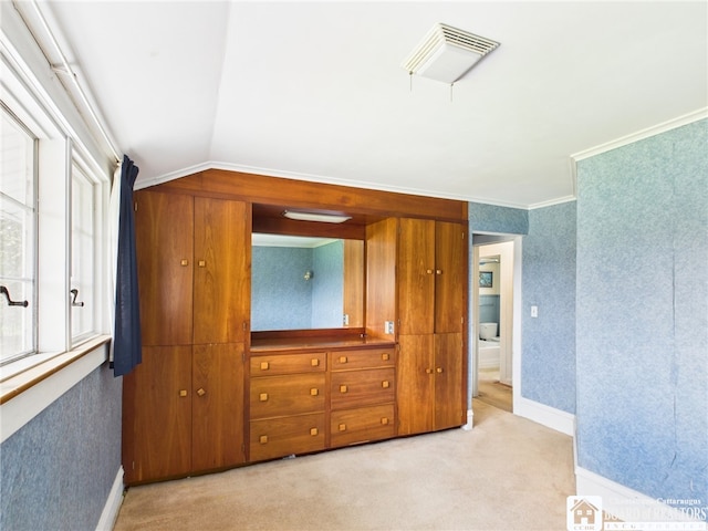 bedroom with visible vents, light colored carpet, vaulted ceiling, baseboards, and wallpapered walls