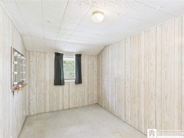 carpeted empty room with wood walls