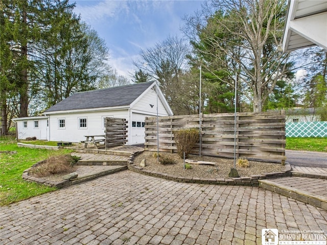 exterior space featuring fence and an outbuilding
