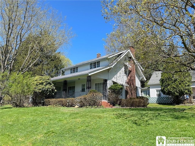view of front facade featuring a porch, a front lawn, and a chimney