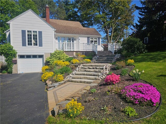 16 Coolidge Ave, Ogden, NY 14559 - view of front facade with a chimney, an attached garage, asphalt driveway, a deck, and stairs