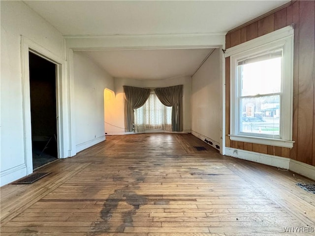 spare room with visible vents, arched walkways, and hardwood / wood-style floors