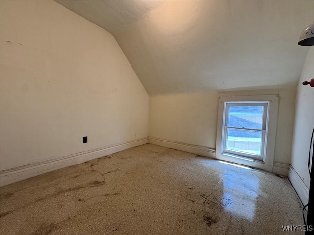 bonus room featuring baseboards and vaulted ceiling