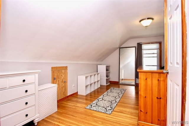 additional living space featuring wood finished floors and lofted ceiling