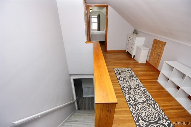 stairs with vaulted ceiling and wood finished floors