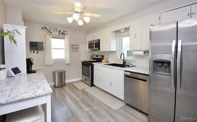 kitchen featuring a sink, appliances with stainless steel finishes, plenty of natural light, and ceiling fan