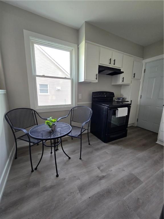 kitchen with electric range, baseboards, white cabinetry, under cabinet range hood, and light wood-style flooring