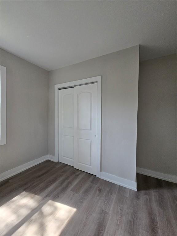 506 Luce St, Elmira-City, NY 14904 - unfurnished bedroom featuring wood finished floors, baseboards, and a closet