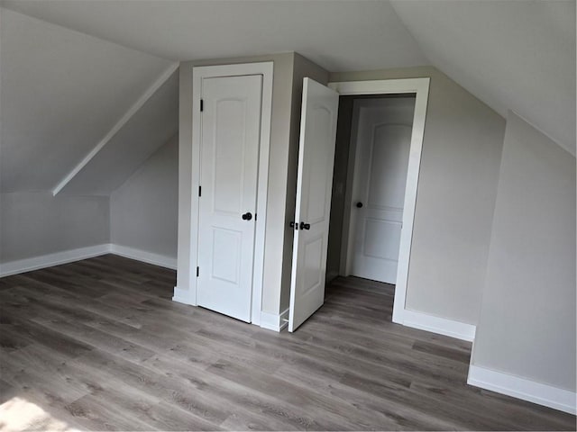 bonus room featuring baseboards, wood finished floors, and vaulted ceiling