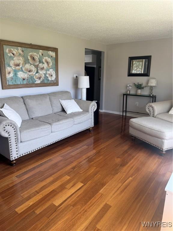 living room with a textured ceiling and wood finished floors