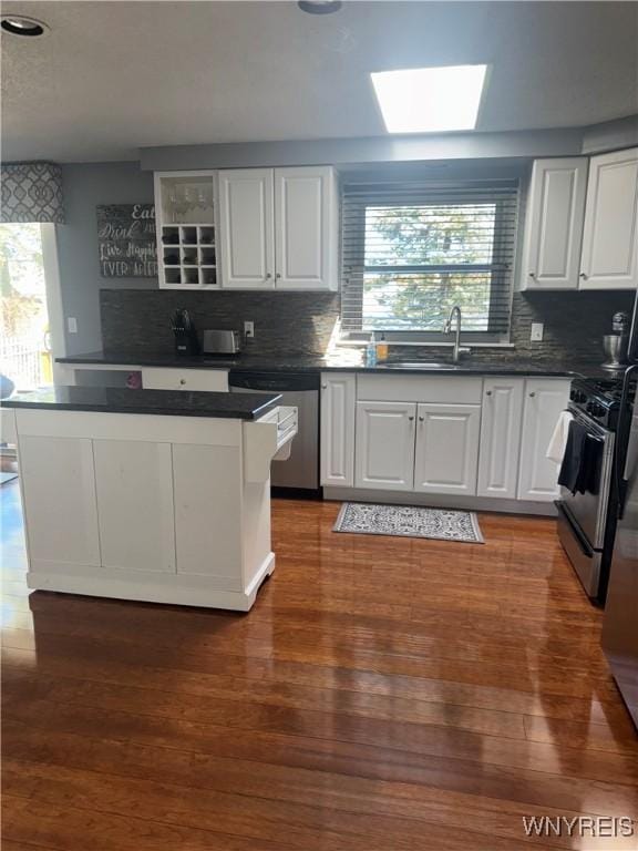 kitchen featuring decorative backsplash, stainless steel appliances, and white cabinets