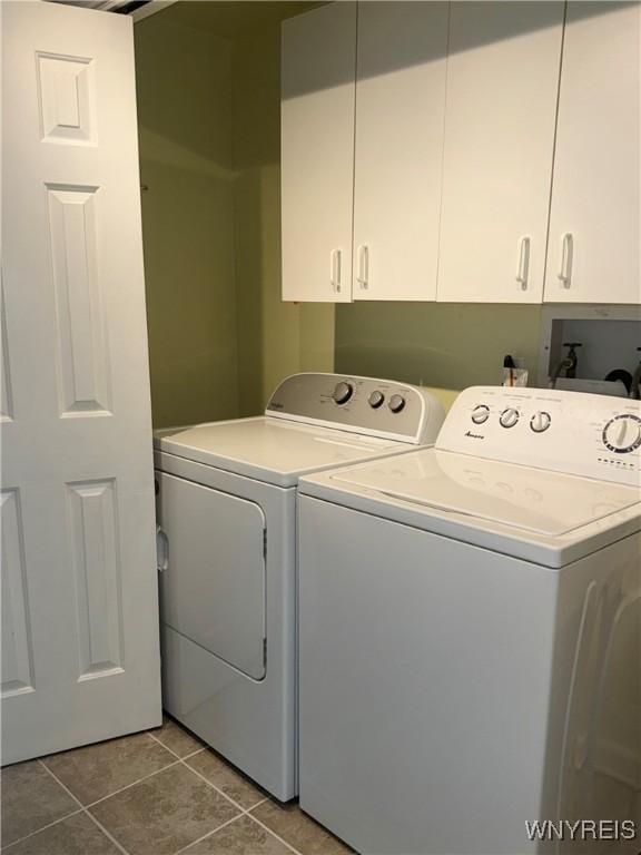 laundry area with tile patterned floors, cabinet space, and washing machine and dryer