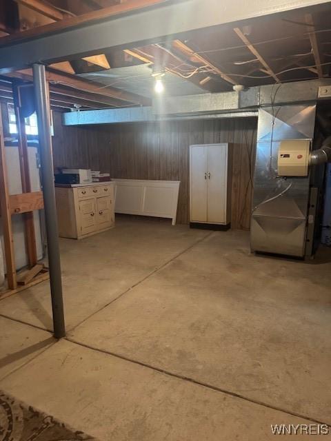 unfinished below grade area with wooden walls and heating unit