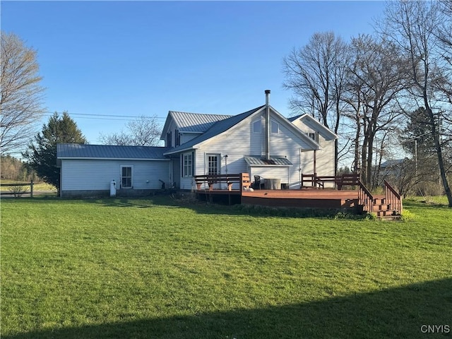 rear view of house featuring a yard, a wooden deck, and metal roof