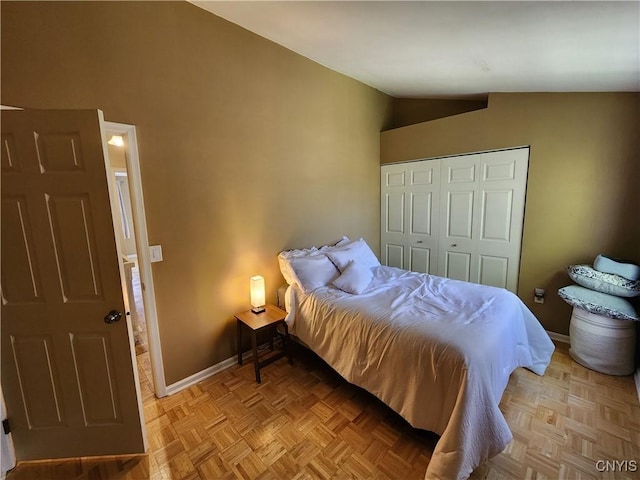 bedroom with baseboards, a closet, and lofted ceiling