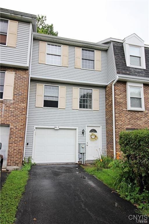 4407 Heritage Dr, Clay, NY 13090 - view of property featuring brick siding, a garage, and driveway