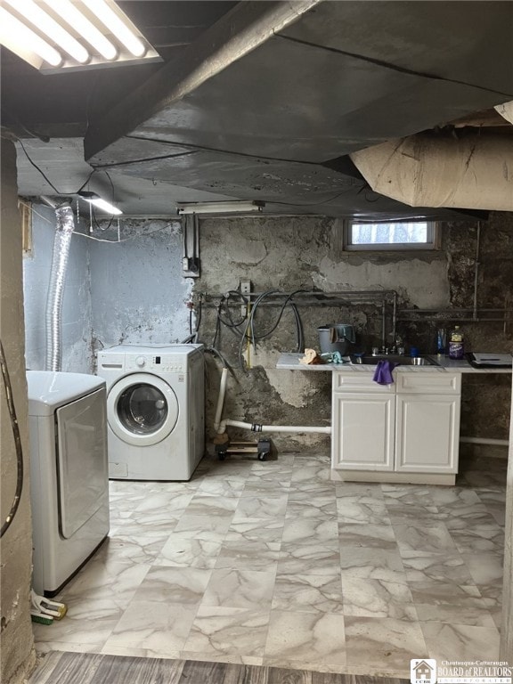laundry area with independent washer and dryer and a sink