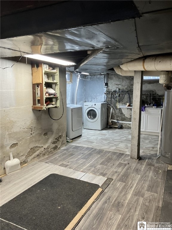unfinished below grade area featuring water heater, washing machine and dryer, and wood finished floors