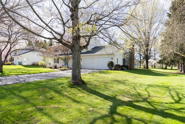 view of front facade with an attached garage, a front yard, and aphalt driveway