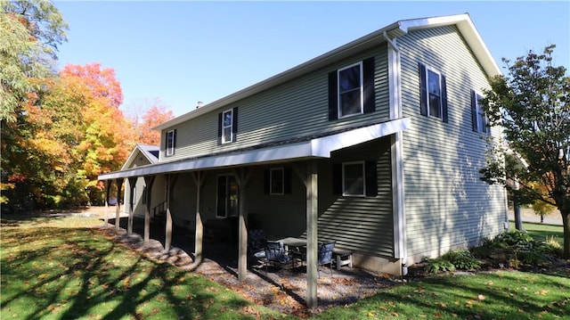 rear view of house featuring a lawn