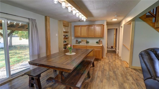 dining area featuring light wood-style floors and stairs