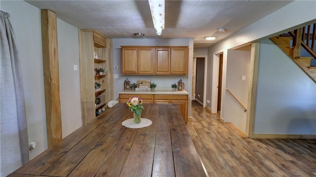 kitchen featuring light countertops, open shelves, and wood finished floors
