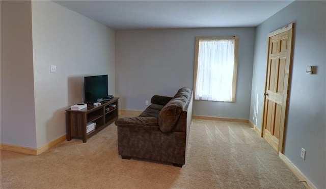 living area with baseboards and light carpet