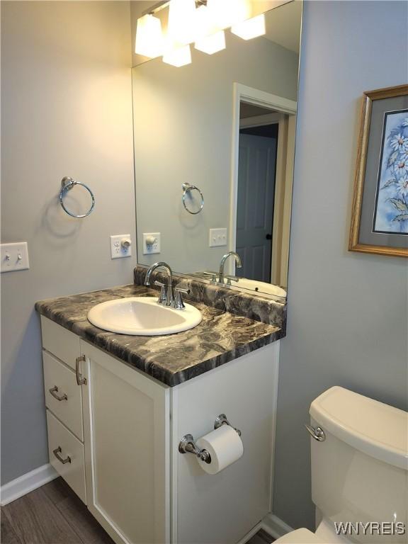 5260 Murphy Rd, Orchard Park, NY 14127 - half bath with vanity, wood finished floors, and toilet