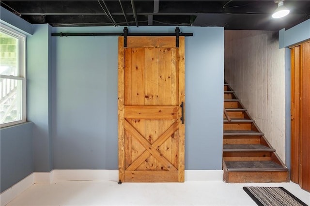 below grade area featuring a barn door and stairway