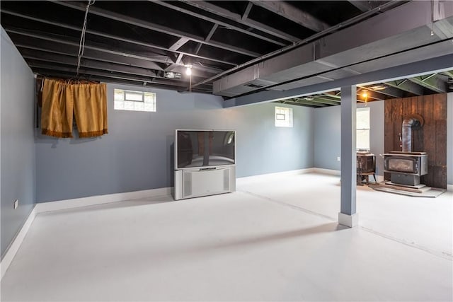 below grade area featuring plenty of natural light and a wood stove