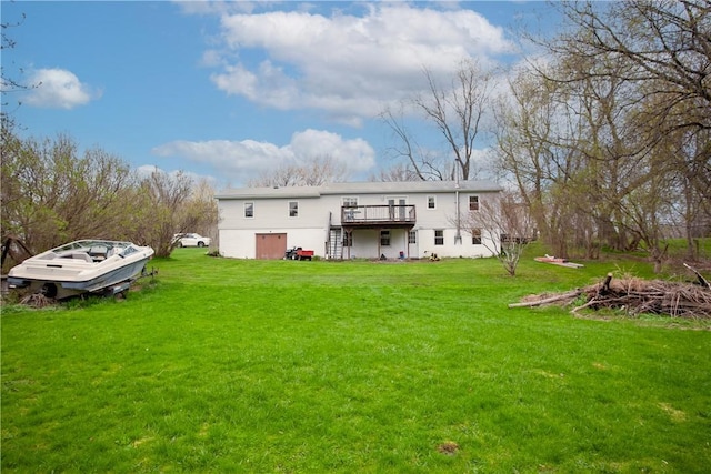 rear view of property featuring a lawn, stairway, and a wooden deck