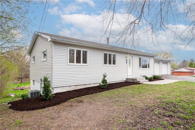 ranch-style house with concrete driveway, an attached garage, and cooling unit