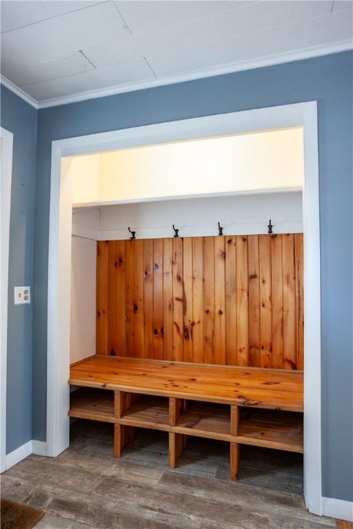 mudroom featuring crown molding, baseboards, and wood finished floors