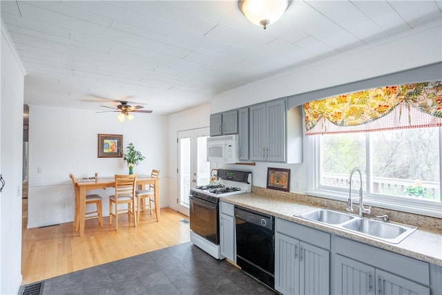kitchen featuring plenty of natural light, a sink, visible vents, and white appliances