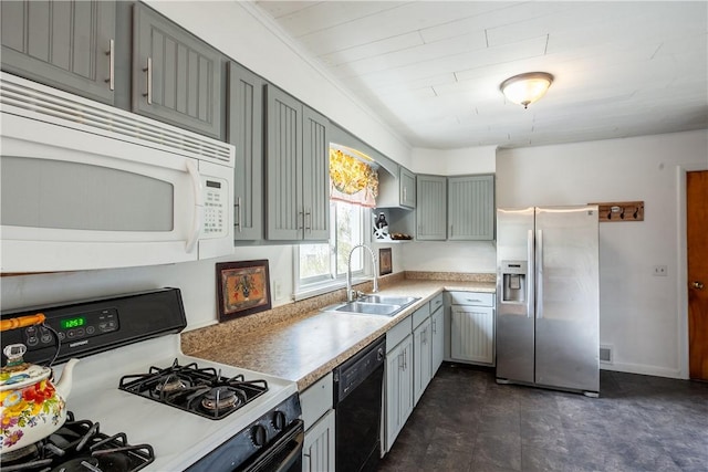 kitchen with a sink, white microwave, stainless steel fridge, black dishwasher, and gas range oven