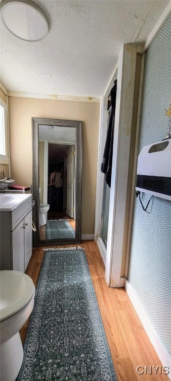 bathroom featuring toilet, baseboards, wood finished floors, and vanity