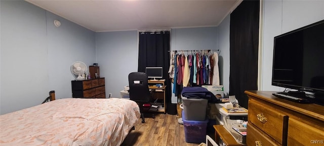 bedroom featuring crown molding and light wood finished floors