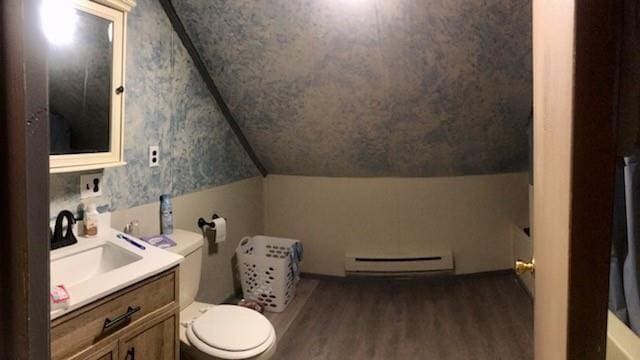 bathroom featuring wood finished floors, vanity, a baseboard heating unit, toilet, and lofted ceiling