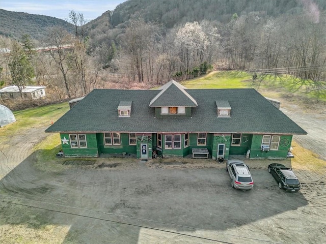 view of front facade featuring a mountain view and dirt driveway