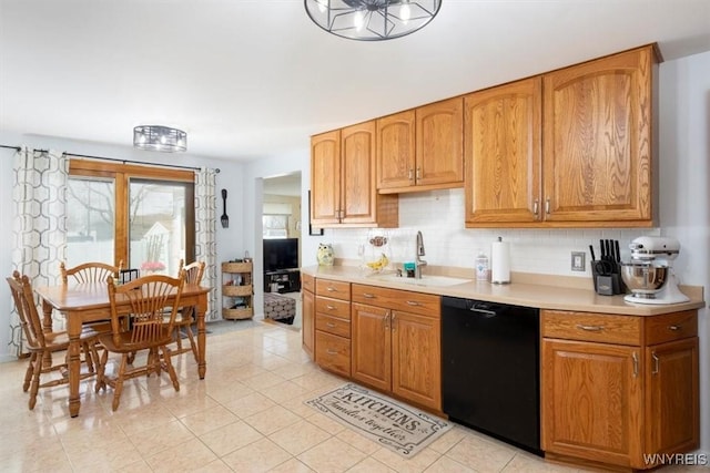 kitchen with a sink, dishwasher, light countertops, light tile patterned floors, and tasteful backsplash