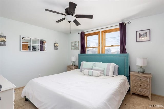 bedroom featuring ceiling fan, light colored carpet, and baseboards